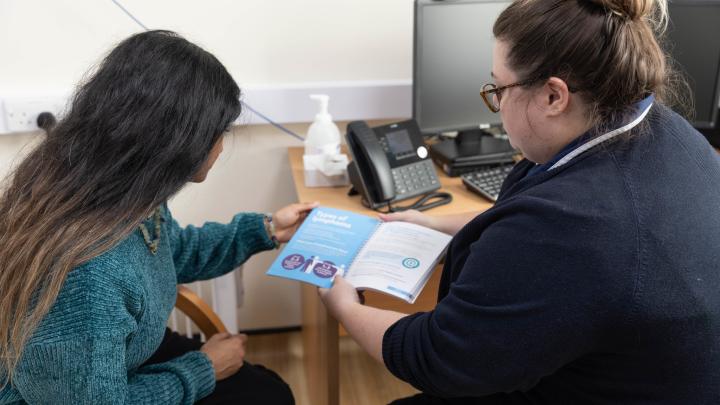 Nurse discussing content of information book with patient