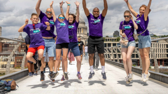 Lymphoma Action supporters jumping against a backdrop of a London bridge. 