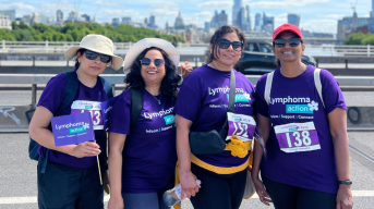 Four Lymphoma Action supporters smiling to camera against a backdrop of London scenery. They are taking part in Lymphoma Action's Bridges of London walking event.
