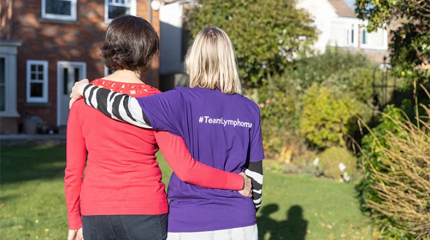 Two ladies looking away from camera with arms around each other