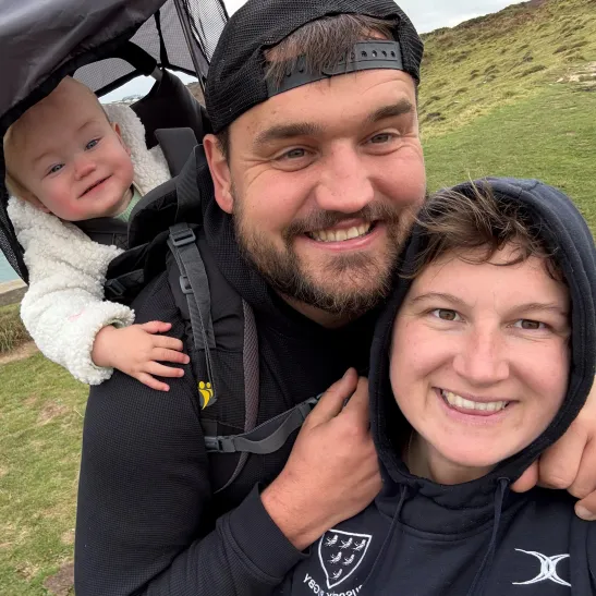A selfie of Katie, her partner and young baby
